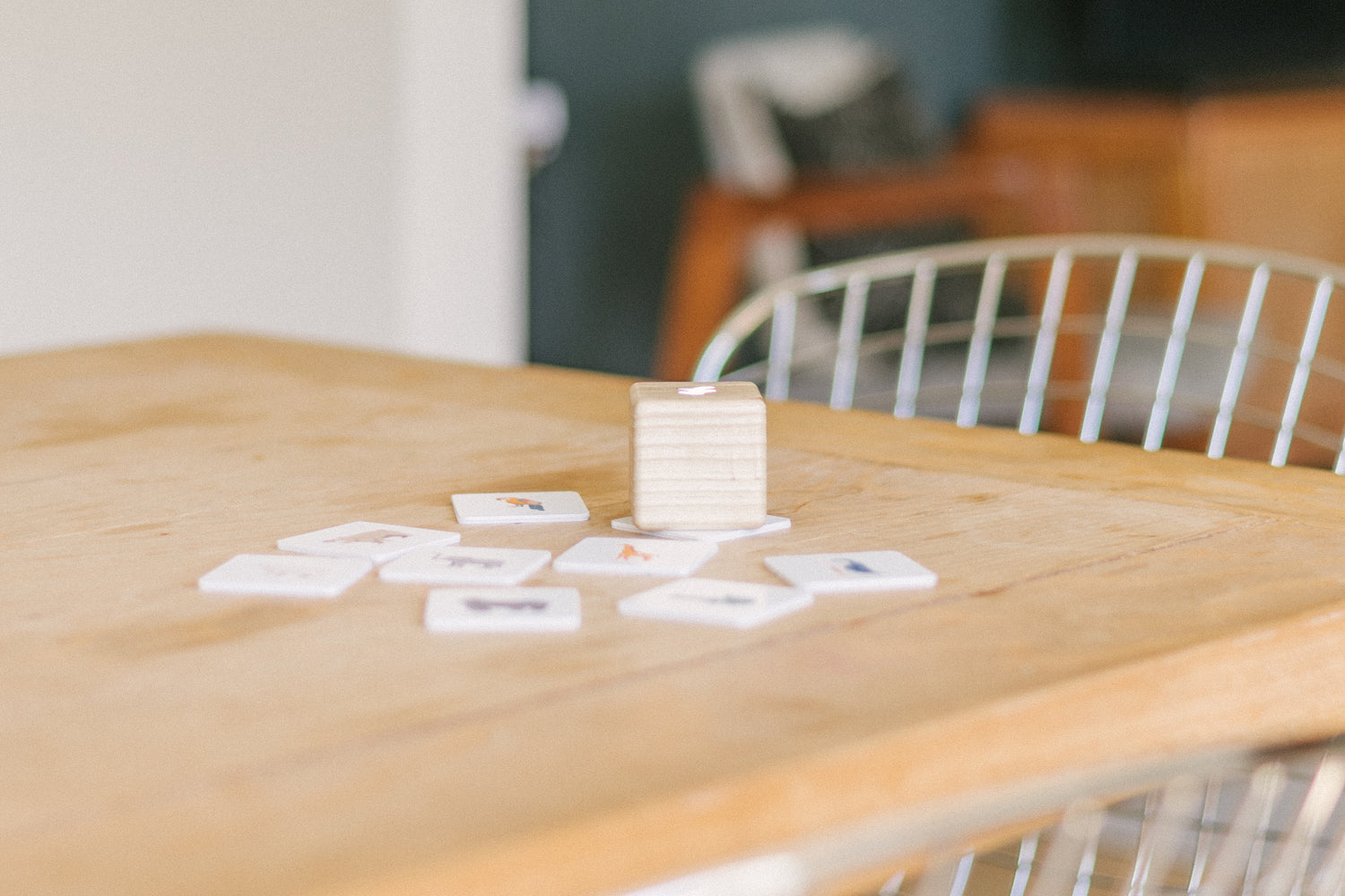 Kiri Smart Block and nine tiles on a wooden table set in front of a chair pushed under the table