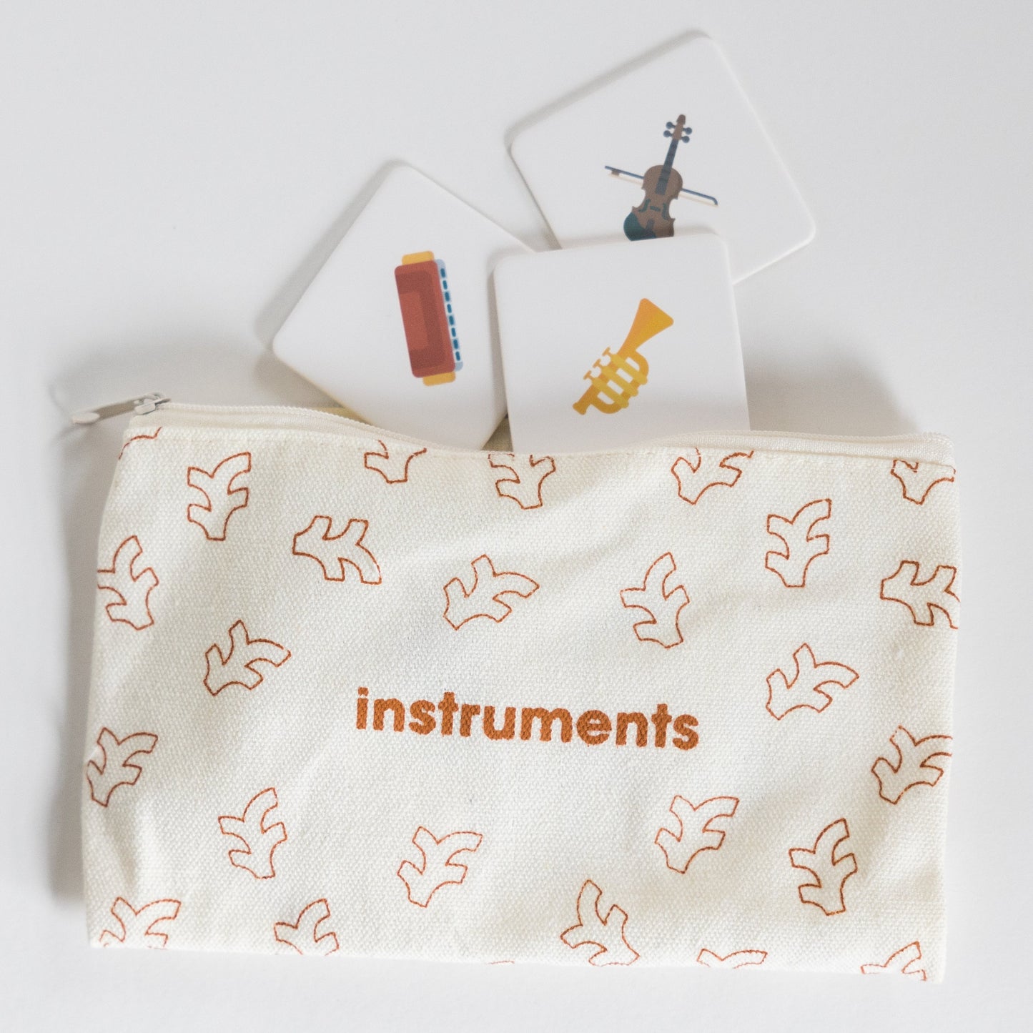 Cloth zippered Instruments Tile Pack pouch on white background with four tiles spilling out