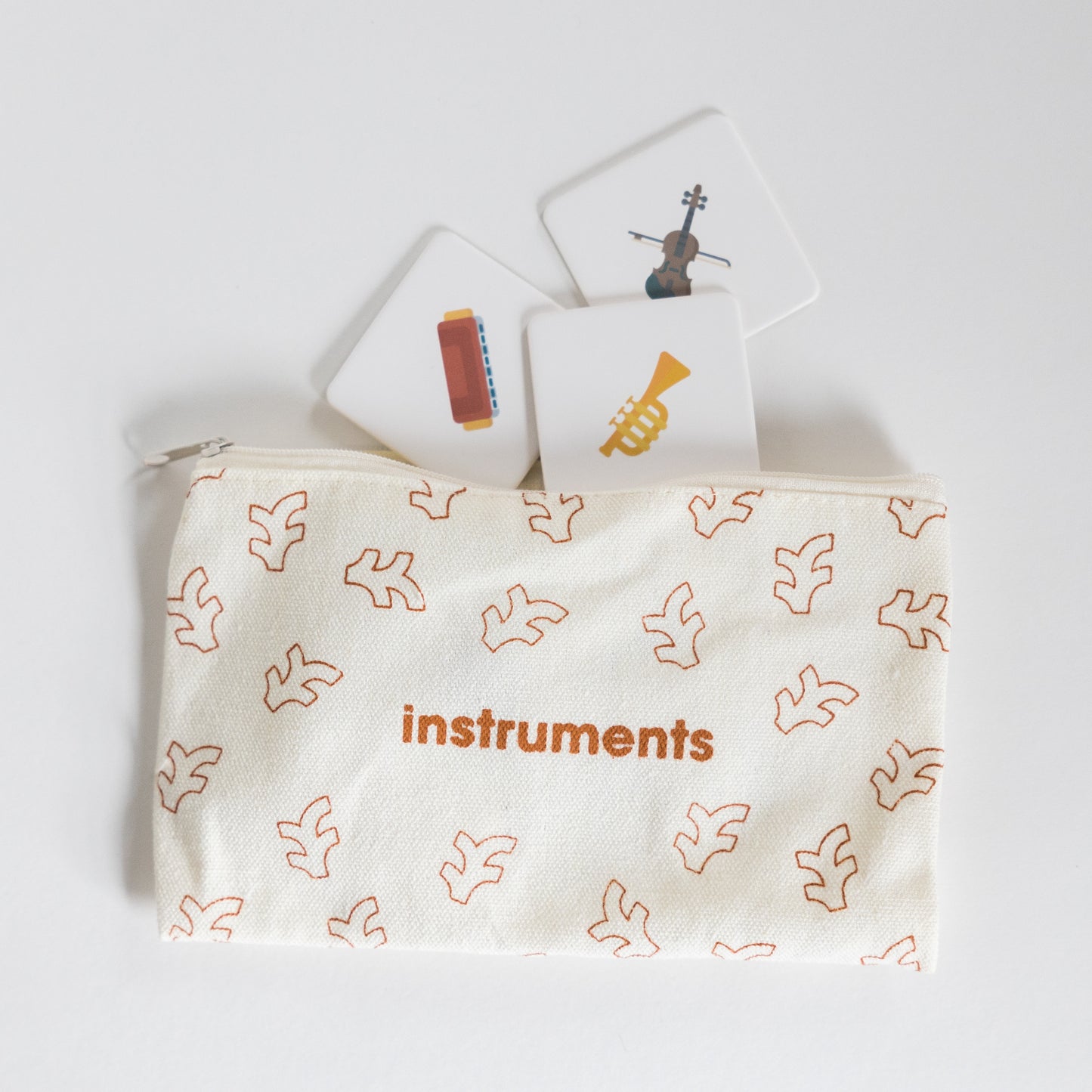 Cloth zippered Instruments Tile Pack pouch on white background with three tiles spilling out