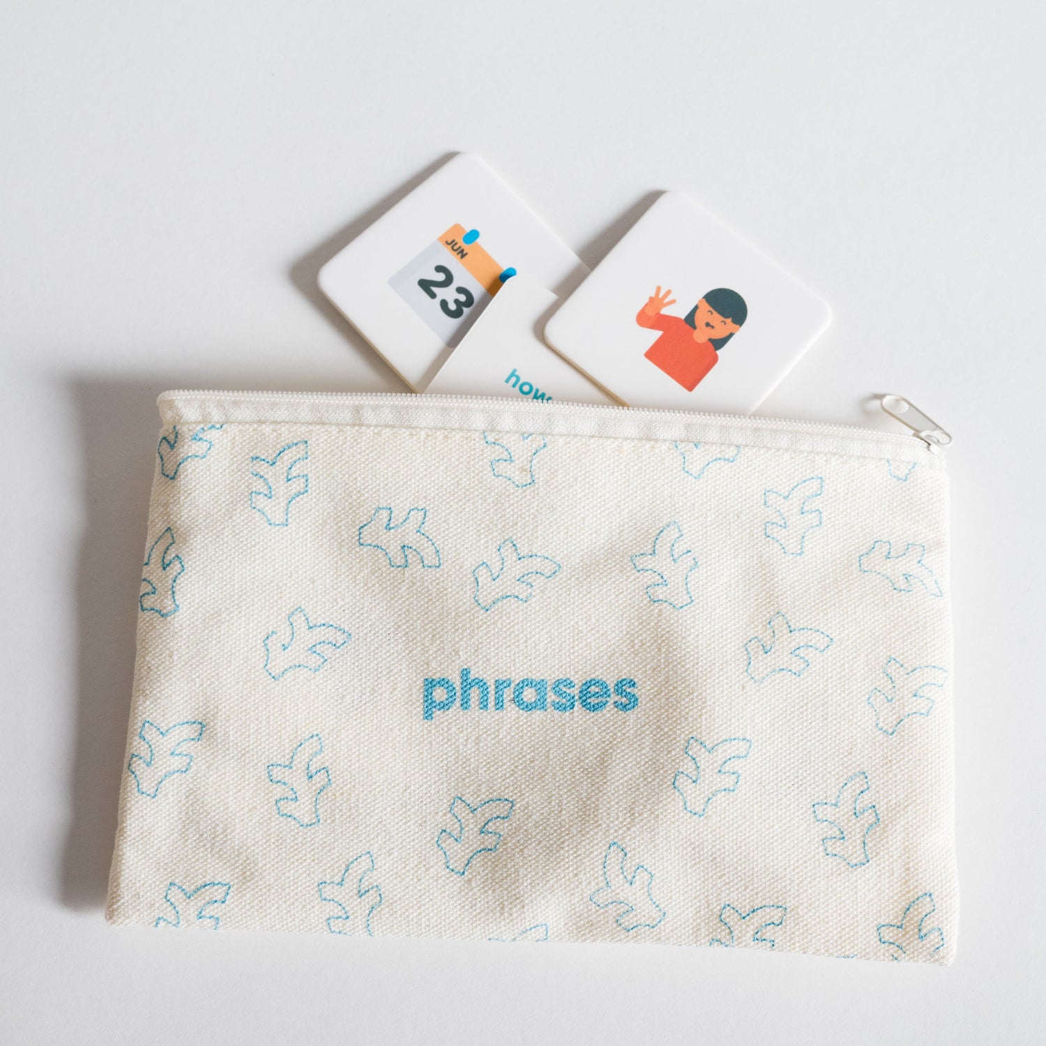 Cloth zippered Phrases Tile Pack pouch on white background with four tiles spilling out