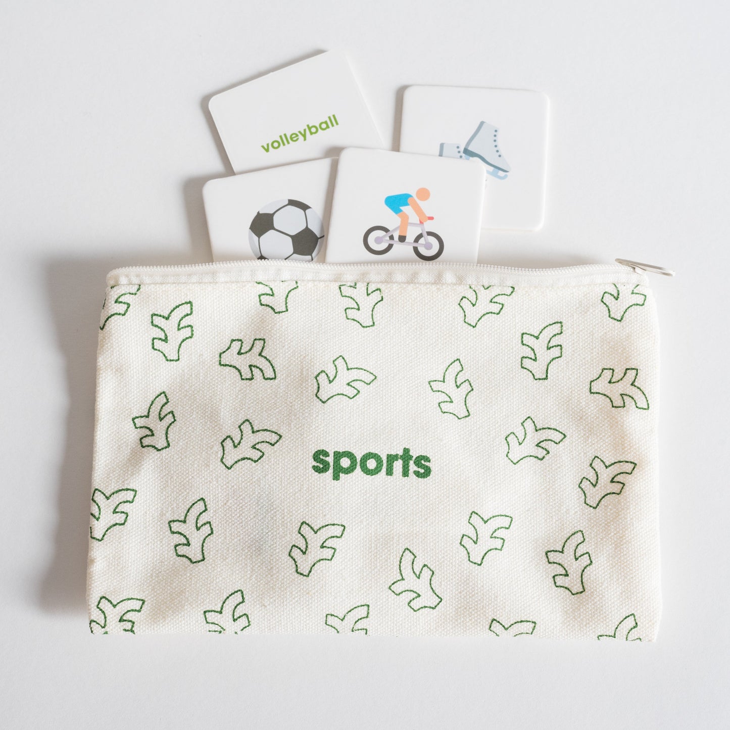 Cloth zippered Sports Tile Pack pouch on white background with four tiles spilling out