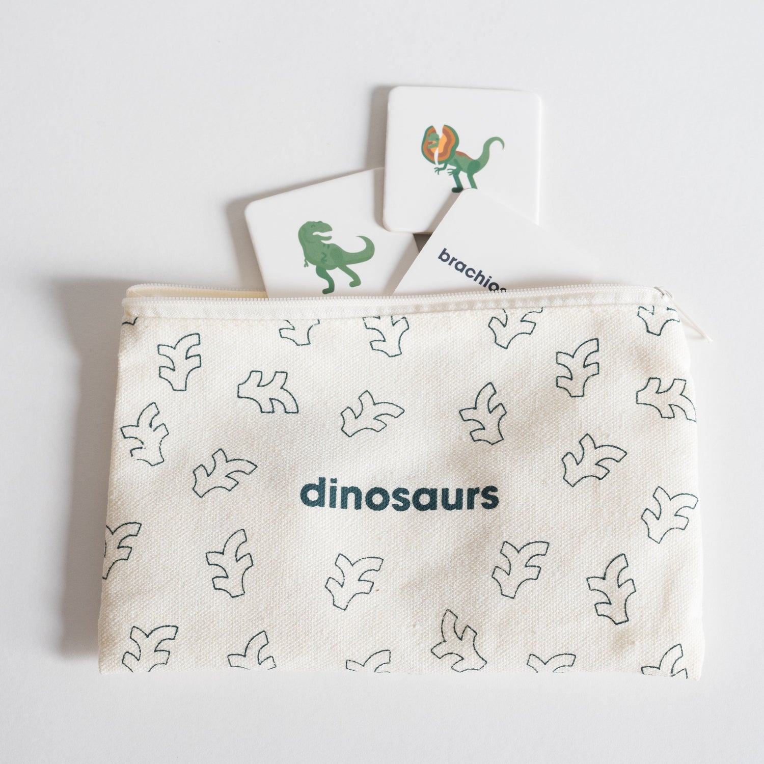 Cloth zippered Dinosaurs Tile Pack pouch on white background with four tiles spilling out