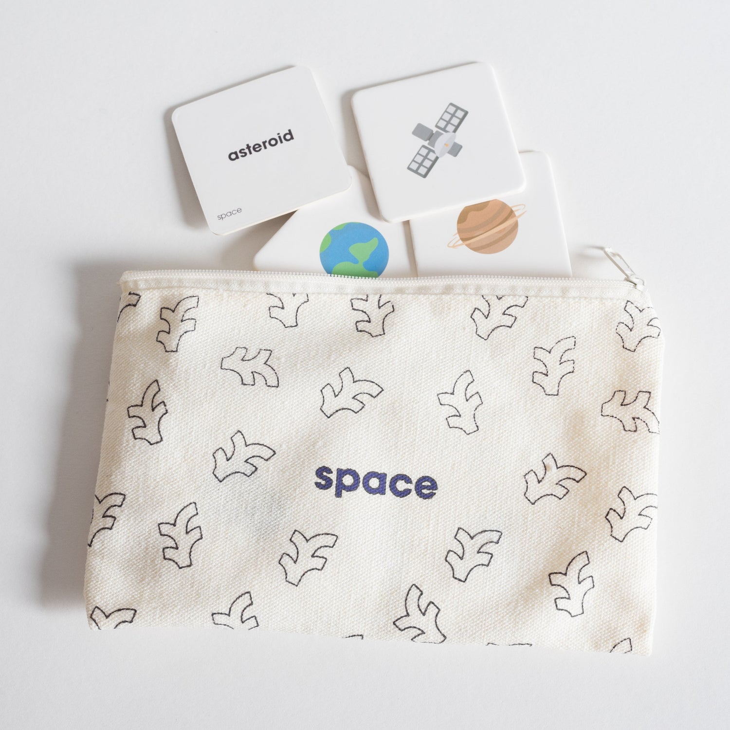 Cloth zippered Space Tile Pack pouch on white background with four tiles spilling out