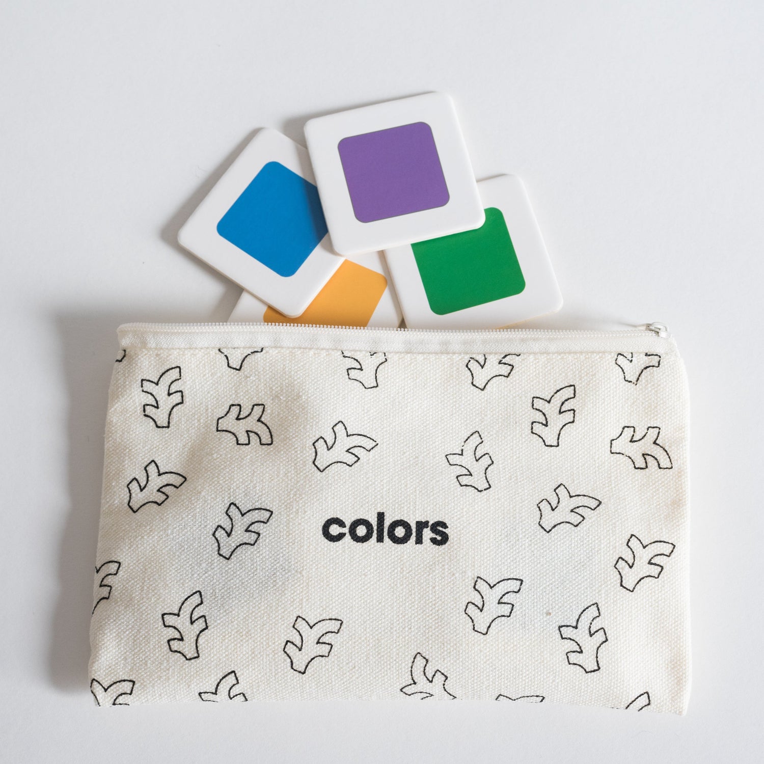 Cloth zippered Colors Tile Pack pouch on white background with four tiles spilling out