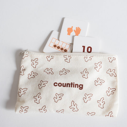 Cloth zippered Counting Tile Pack pouch on white background with four tiles spilling out