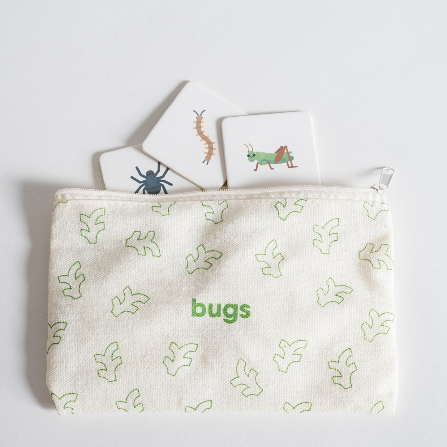 Cloth zippered Bugs Tile Pack pouch on white background with four tiles spilling out