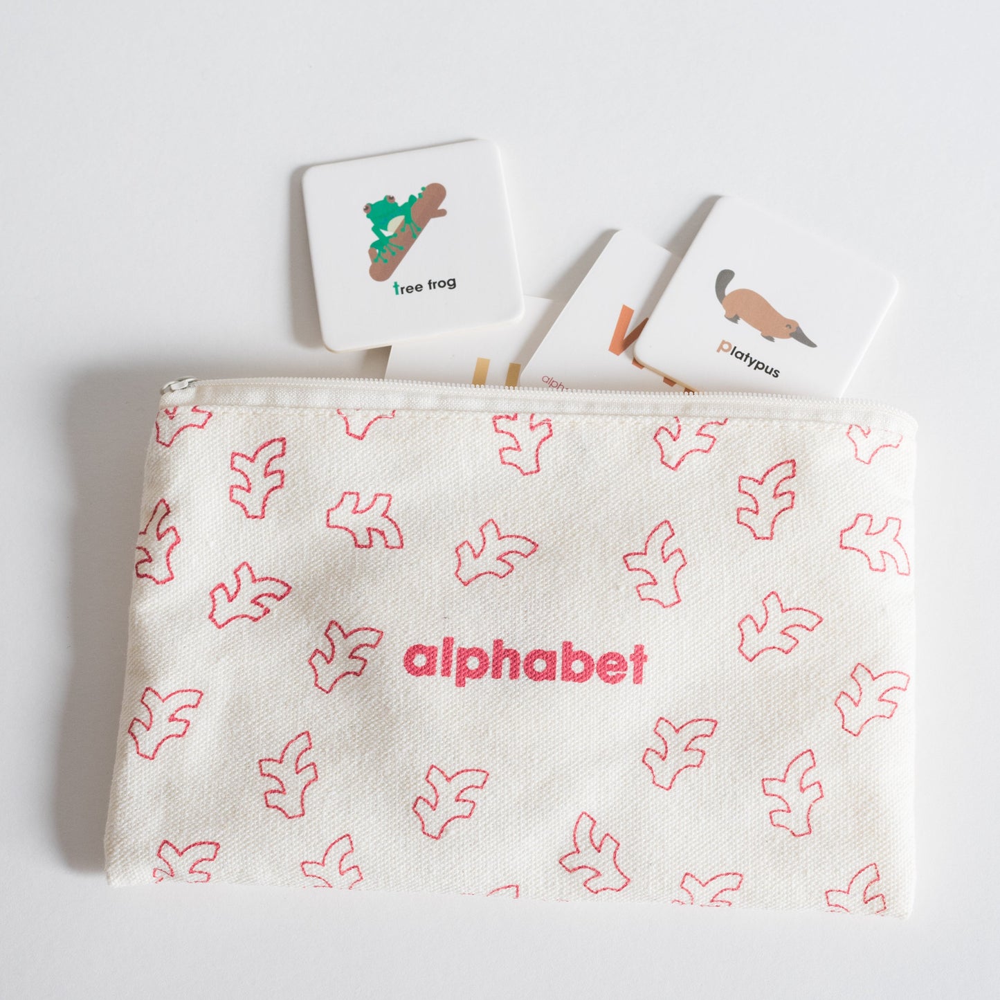 Cloth zippered Alphabet Tile Pack pouch on white background with four tiles spilling out