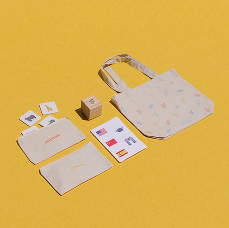 Two tile pack pouches, an instruction manual, the Smart  Block, and tote bag arranged on a yellow background